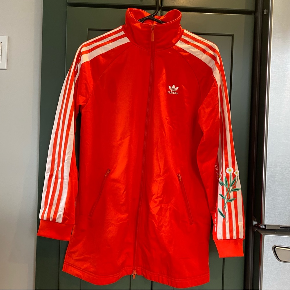 Adidas track jacket with embroidered flowers and quote.